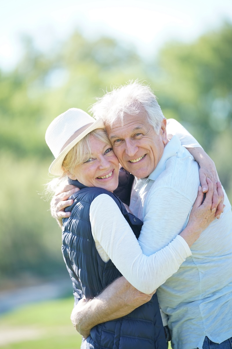 Cheerful senior couple embracing each other in countryside