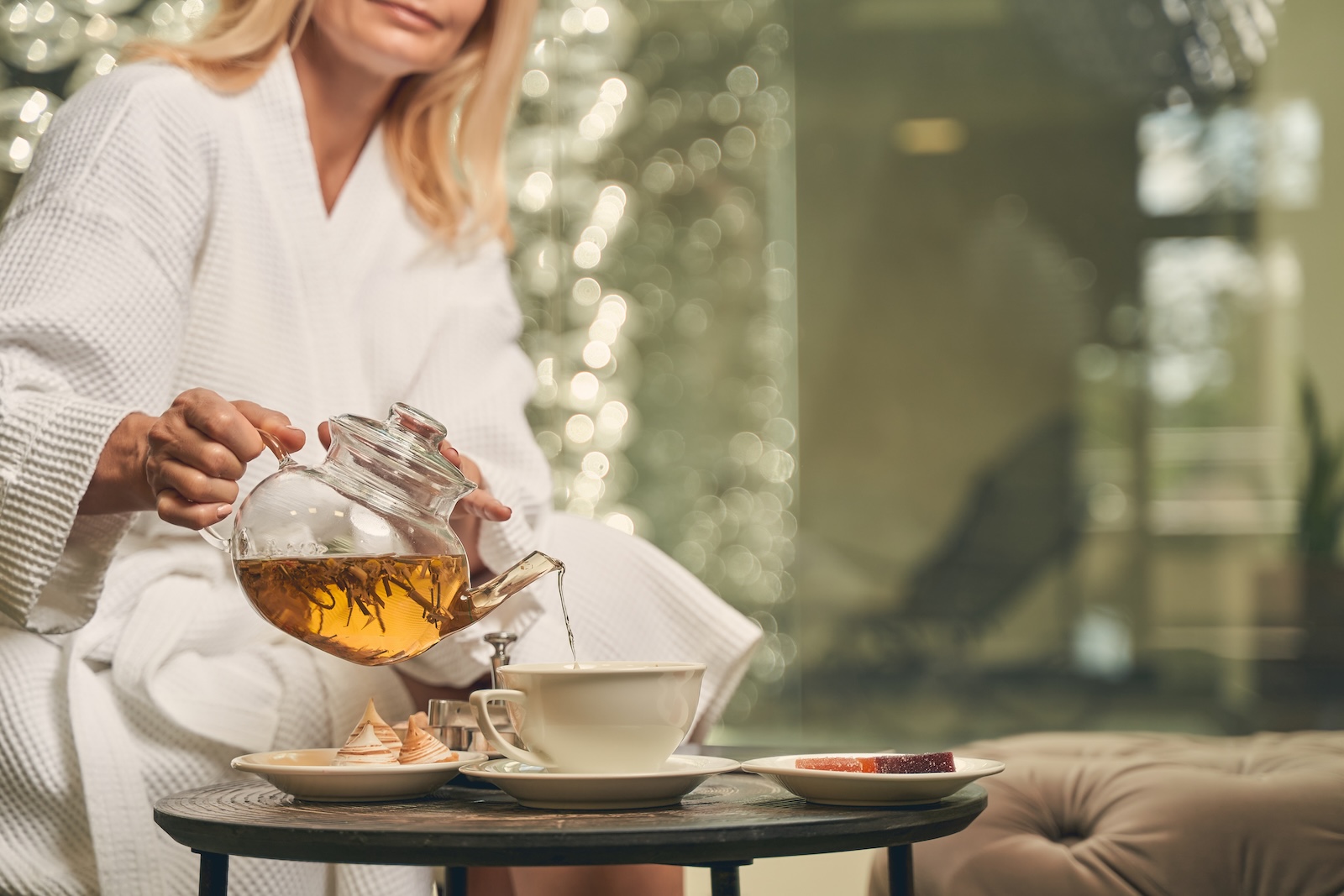 Female pouring green tea in a cup at the breakfast