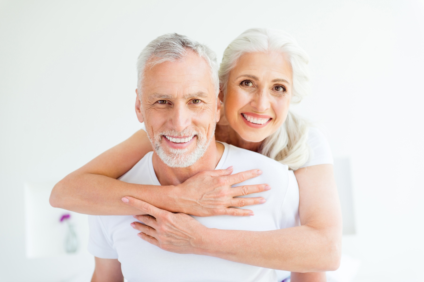 Two happy people in pajama hugging and smiling